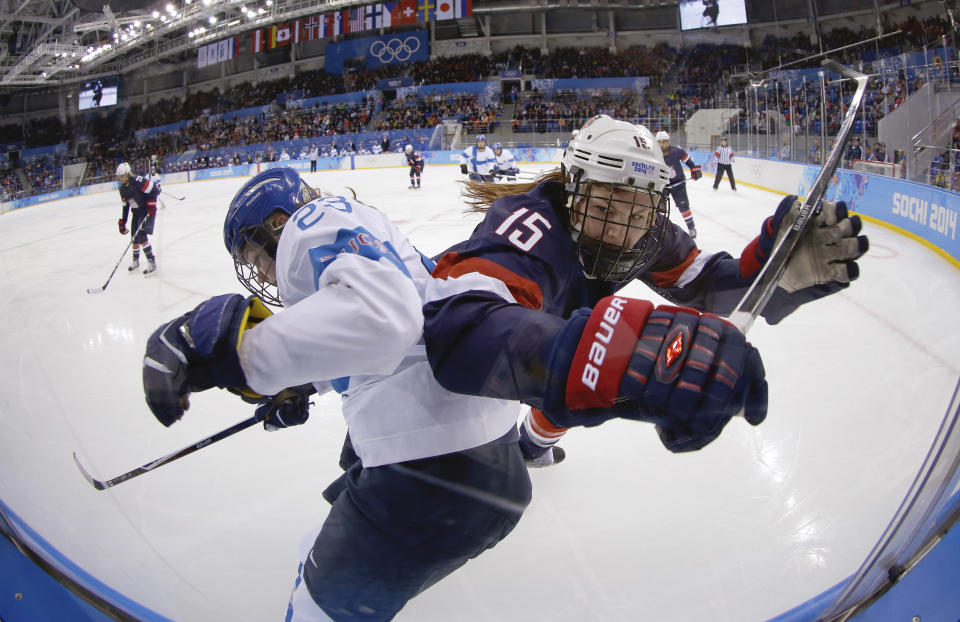 Nina Tikkinen of Finland and Anne Schleper of the United States battlers from control of the puck against the glass during the second period of the women's ice hockey game at the Shayba Arena during the 2014 Winter Olympics, Saturday, Feb. 8, 2014, in Sochi, Russia. 