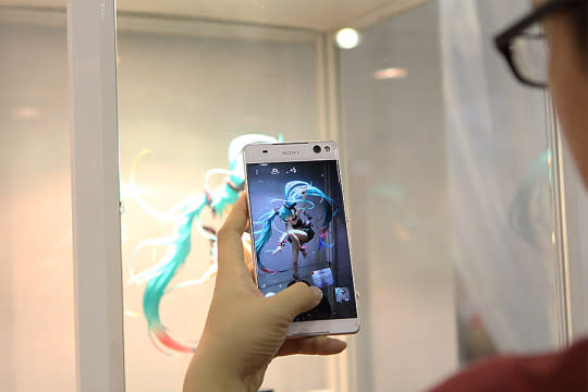 An anime lover taking a picture of an anime character figurine. (Photo: Sharlene Sankaran/Yahoo Singapore)