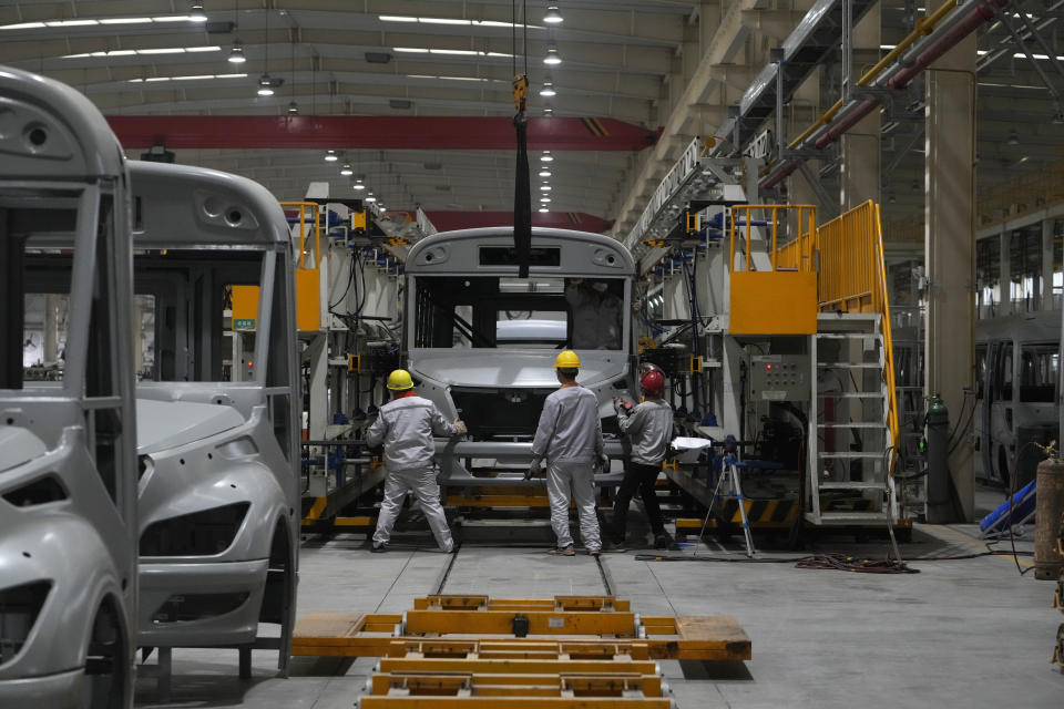 Workers assemble a minibus at a Tenglong Automobile Co. manufacturing factory during a media-organized tour in Xiangyang in central China's Hubei Province on May 10, 2023. China's manufacturing and consumer spending are weakening after a strong start to 2023 after anti-virus controls ended. (AP Photo/Andy Wong)