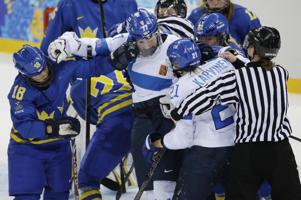 Members of Team Sweden and Team Finland mix it up during the 2014 Winter Olympics women's quarterfinal ice hockey game at Shayba Arena, Saturday, Feb. 15, 2014, in Sochi, Russia. (AP Photo/Matt Slocum)