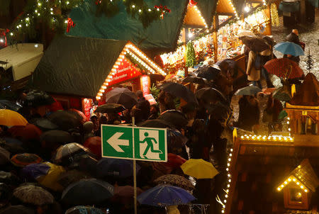 Visitors are seen under an emergency sign exit during the official opening of the traditional Christmas market in Frankfurt, Germany, November 27, 2017. REUTERS/Kai Pfaffenbach