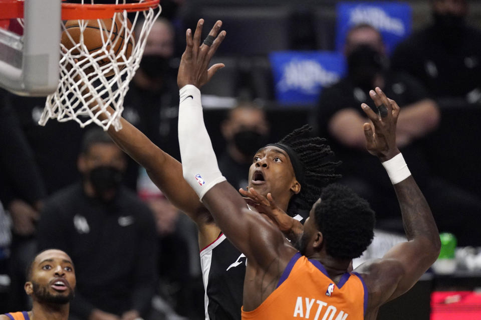 Los Angeles Clippers guard Terance Mann, top, shoots as Phoenix Suns center Deandre Ayton defends during the second half in Game 3 of the NBA basketball Western Conference Finals Thursday, June 24, 2021, in Los Angeles. (AP Photo/Mark J. Terrill)