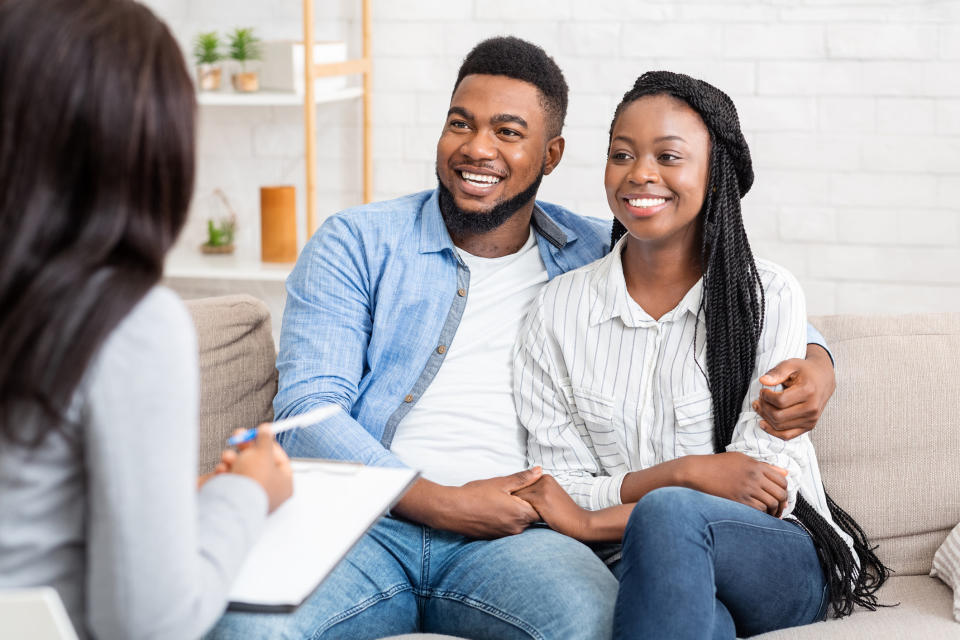 a couple hugging on a couch during counseling