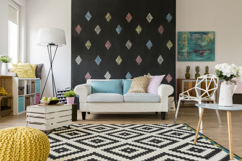 Spacious living room with a big sofa and a blackboard wall