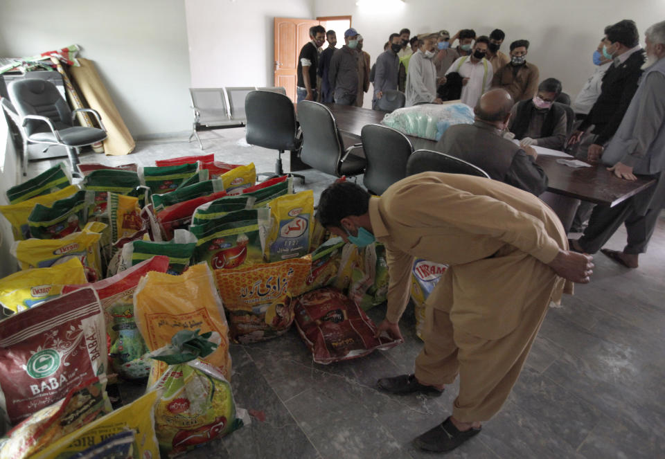 Daily wages workers receive free food supplies provided by a municipally office during a government imposed nationwide lockdown to try to contain the outbreak of the coronavirus, in Islamabad, Pakistan, Monday, April 6, 2020. The . (AP Photo/Anjum Naveed)