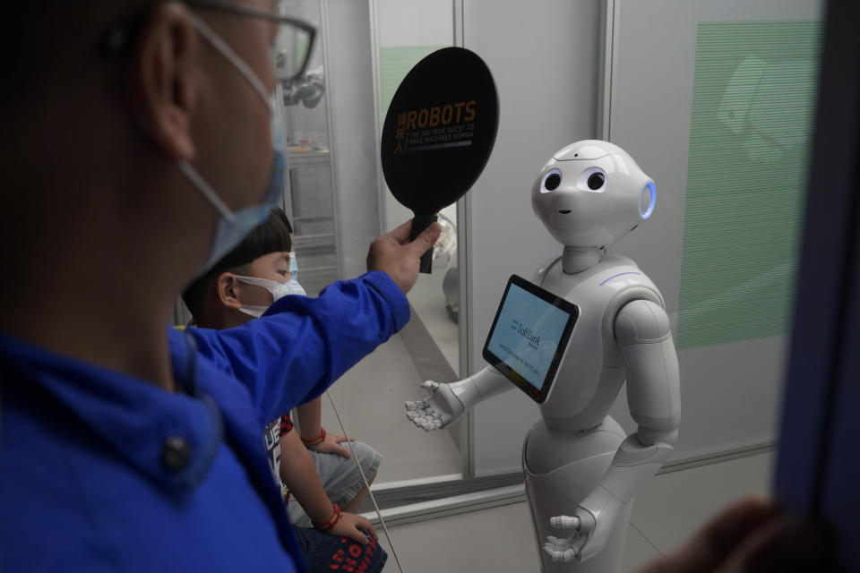 French robot "Pepper the droid" looks at the signal from a staff member at the exhibition "Robots – The 500-Year Quest to Make Machines Human" in the Hong Kong Science Museum, Wednesday, May 19, 2021. (AP Photo/Kin Cheung)