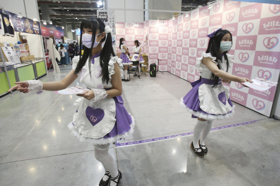 Showgirls wear face masks at the Comic Exhibition in Taipei, Taiwan, Sunday, Feb. 2, 2020. A viral outbreak that began in China has infected more than 11,900 people globally. (AP Photo/Chiang Ying-ying)