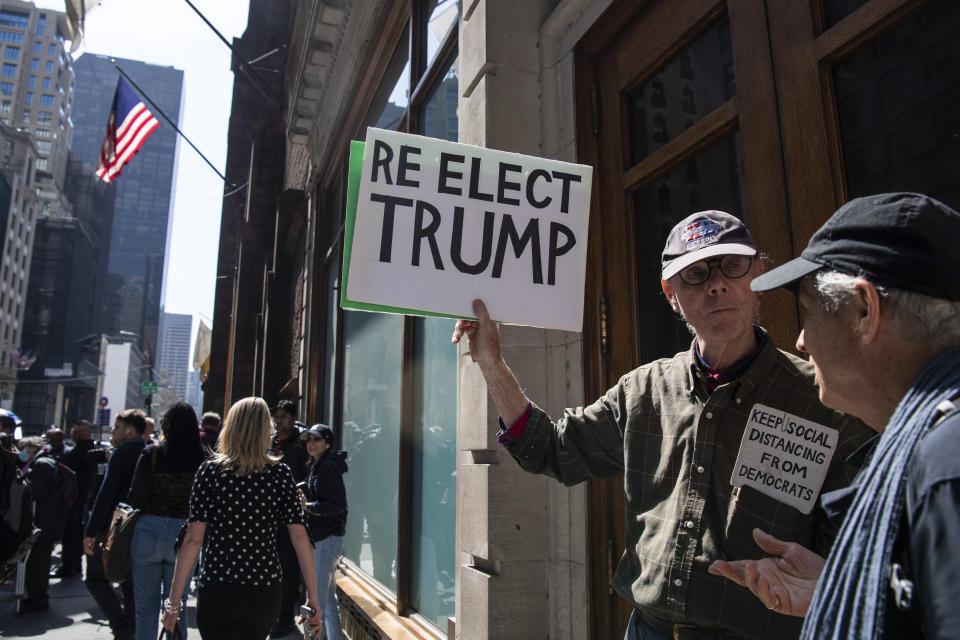 Un partidario del expresidente Donald Trump, Fred Williams, de 79 años, alza un cartel que dice "reelegir a Trump", en Manhattan, martes 4 de abril de 2023. (AP Foto/Brittainy Newman)