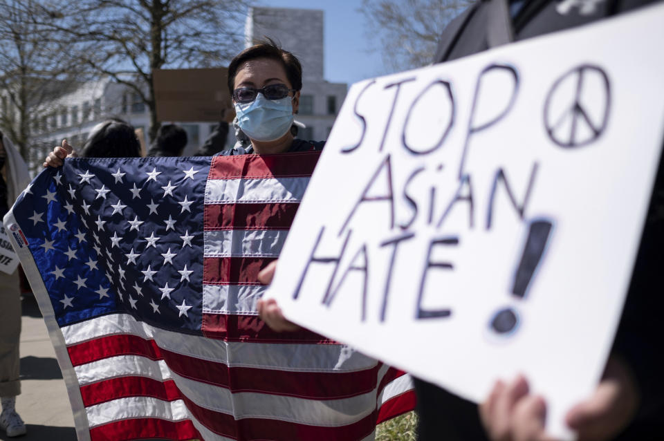 Lucy Lee, of Marietta, Ga., holds an American flag while rallying outside of the Georgia State Capitol in Atlanta during a unity "Stop Asian Hate" rally Saturday afternoon, March 20, 2021. (AP Photo/Ben Gray)