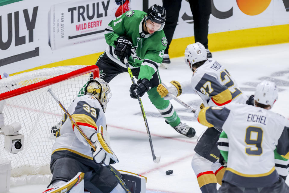 Dallas Stars left wing Jason Robertson, center, shoots as Vegas Golden Knights goalie Adin Hill defends during the first period of Game 4 of the NHL hockey Stanley Cup Western Conference finals Thursday, May 25, 2023, in Dallas. (AP Photo/Gareth Patterson)