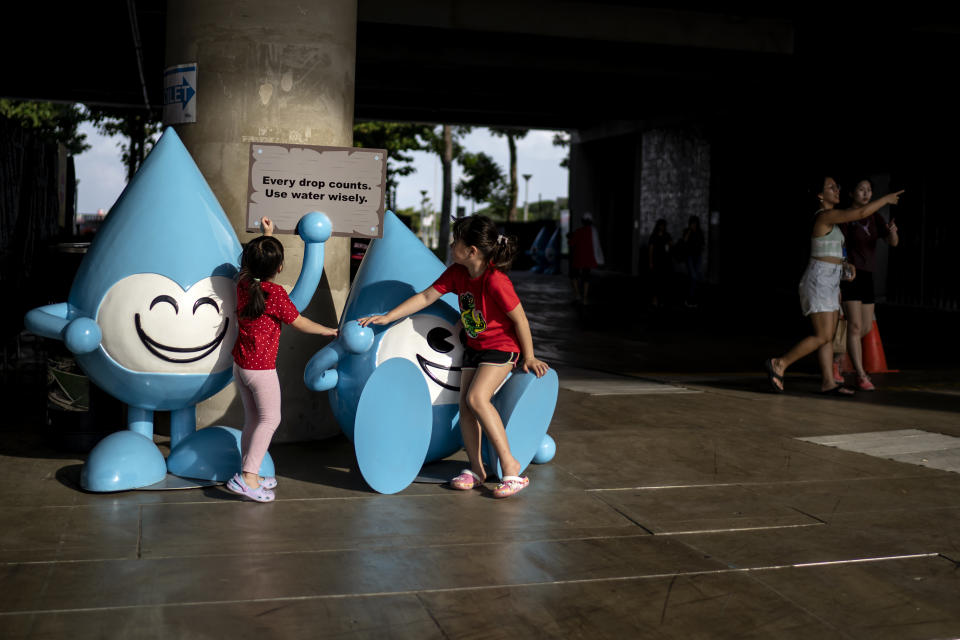 Girls play on water drop statues, part of a promotional campaign to educate the public on water conservation, at Marina Barrage in Singapore, Saturday, July 22, 2023. Water has long been a vulnerability for the tropical island nation of Singapore, which gained freedom from neighboring Malaysia in the 1960s. Politics with Malaysia, which still supplies some of its water, climate change and a population boom have made Singapore's quest for water independence much more urgent. Solutions the country now uses now are among the most advanced in the world. (AP Photo/David Goldman)