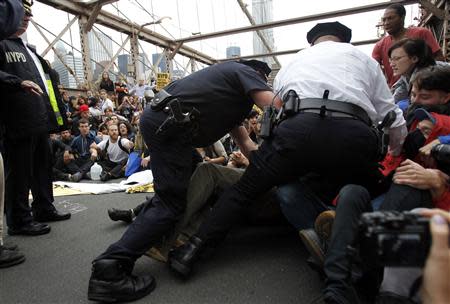 Police officers reach into a crowd of protesters to make an arrest on the Brooklyn Bridge during an Occupy Wall Street march in New York in this October 1, 2011 file photo. REUTERS/Jessica Rinaldi/Files