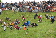 Im englischen Brockworth ist man sich nicht zu schade, auf einem steil abfallenden Hang einem Käselaib hinterherzurennen. Beim jährlichen „Cheese Rolling Race“ kommen die Teilnehmer schon nach wenigen Metern gehörig ins Wanken. (Bild: Joe Giddens/PA via AP)