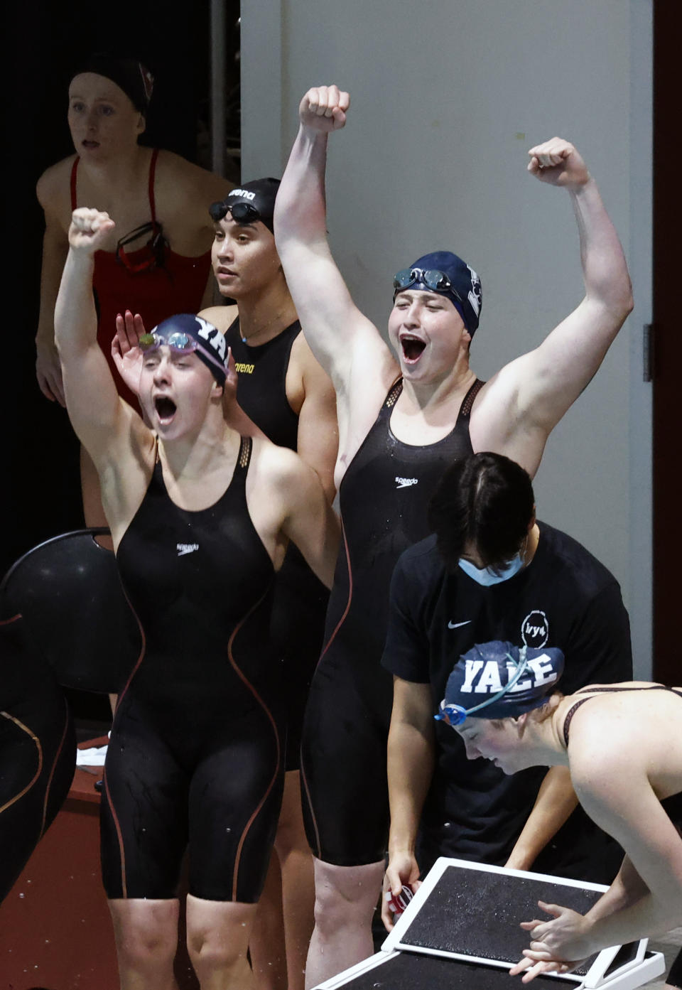 Yale's Iszac Henig, top right, cheers with teammates after working to set a meet and pool record in the 200-yard freestyle relay event at the Ivy League Women's Swimming and Diving Championships at Harvard University, Thursday, Feb. 17, 2022, in Cambridge, Mass. Henig, who is transitioning to male but hasn't begun hormone treatments yet, is swimming for Yale's women's team. (AP Photo/Mary Schwalm)