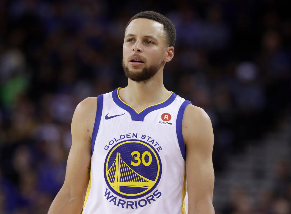 FILE - Golden State Warriors guard Stephen Curry stands on the court during an NBA basketball game against the Brooklyn Nets in Oakland, Calif., March 6, 2018. The bankruptcy of FTX and the arrest of its founder and former CEO are raising new questions about the role celebrity athletes such as Tom Brady, Curry, Naomi Osaka and others played in lending legitimacy to the largely unregulated landscape of crypto, while also reframing the conversation about just how costly blind loyalty to favorite players or teams can be for the average fan. (AP Photo/Jeff Chiu, File)
