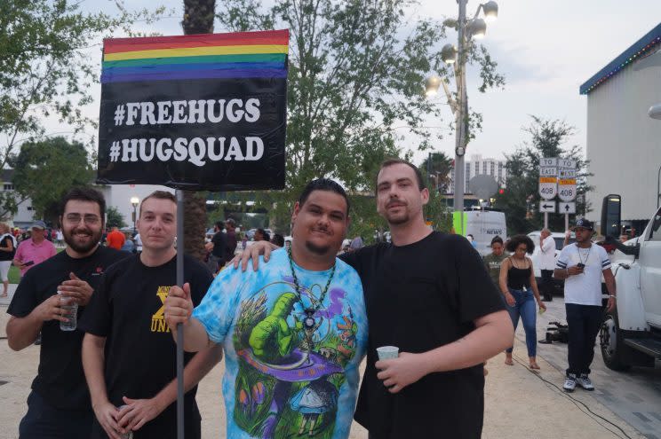 Giovanni Ramirez, center-right, and Casey Cividanes, right, offer free hugs with their friends at the vigil on Monday in downtown Orlando. (Photo: Michael Walsh/Yahoo News)