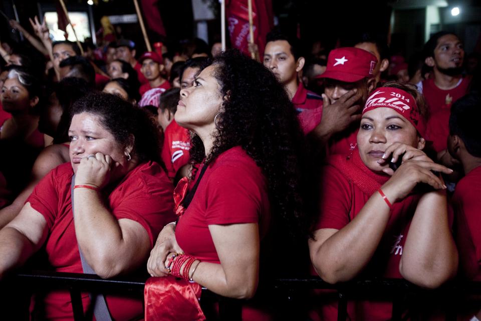 Supporters of the Salvador Sanchez Ceren, presidential candidate, current vice president for the ruling Farabundo Marti National Liberation Front (FMLN) listen to results of the presidential elections during a demonstration in San Salvador, El Salvador, Sunday, Feb. 2, 2014. El Salvador's electoral tribunal said late Sunday that with about 58 per cent of the votes counted, Vice-President Salvador Sanchez had 49 per cent in his bid to extend the rule of the Farabundo Marti National Liberation Front, the party of former civil war guerrillas that won the presidency for the first time in 2009. Sanchez was just under the 50 per cent plus one vote he needed to win outright, but election tribunal chief Eugenio Chicas predicted the candidate would fall short and have to face a runoff. San Salvador Mayor Norman Quijano was second with nearly 39 per cent as the candidate of the long-governing conservative Nationalist Republican Alliance, known as ARENA. (AP Photo/Esteban Felix)