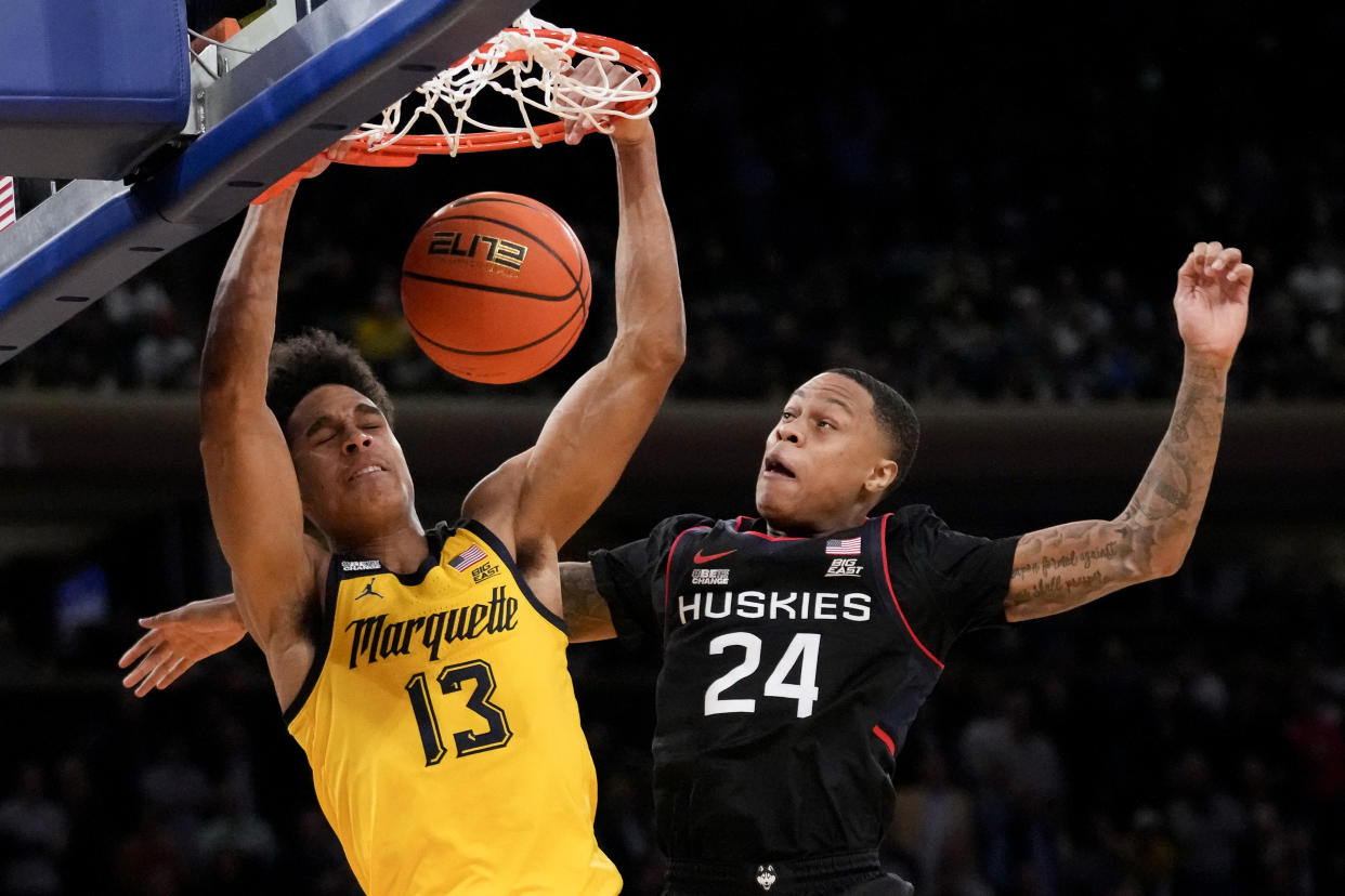 Marquette's Oso Ighodaro (13) dunks against Connecticut's Jordan Hawkins (24) during the Big East tournament. (AP Photo/John Minchillo)