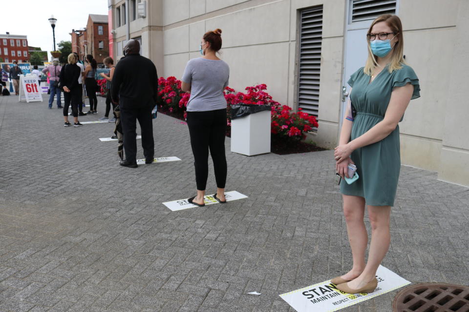 Annie Williams, right, stands in line to vote at one of six in-person voting centers in Baltimore on Tuesday, June 2, 2020. While Maryland's primary was being conducted mostly by mail due to the coronavirus, limited in-person voting was open Tuesday with social distancing guidelines in place. (AP Photo/Brian Witte)