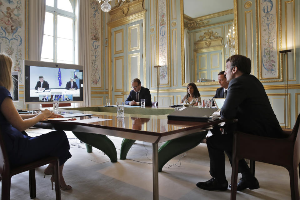 France's President Emmanuel Macron, right, attends a visio conference with Kosovo Prime Minister Avdullah Hoti, Serbian President Aleksandar Vucic, and German Chancellor Angela Merkel, at the Elysee Palace, in Paris, Friday, July 10, 2020. The leaders of Serbia and Kosovo will hold talks in Brussels on July 12, the first meeting between the two in long-stalled European Union-supervised negotiations aimed at normalizing relations, European Commission spokesman Peter Stano said Monday. (AP Photo/Christophe Ena, Pool)