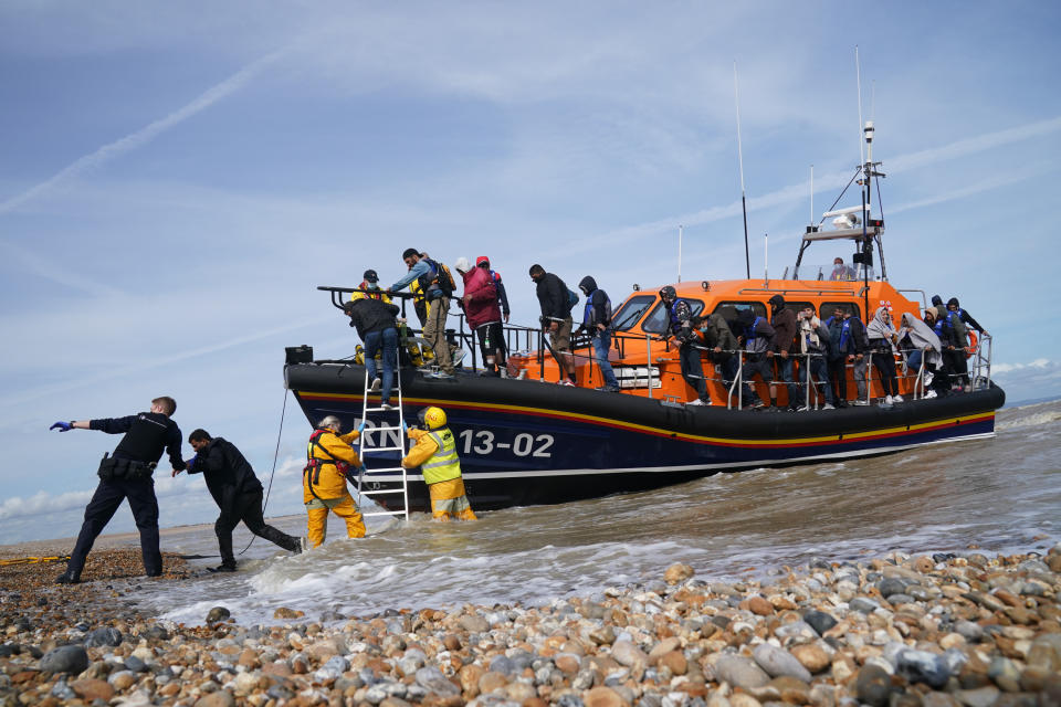 <p>Immigration Enforcement officers and members of the RNLI assist a group of people thought to be migrants from an RNLI lifeboat after they were brought into Dungeness, Kent, by an RNLI lifeboat following a small boat incident in the Channel. Picture date: Monday September 13, 2021.</p>
