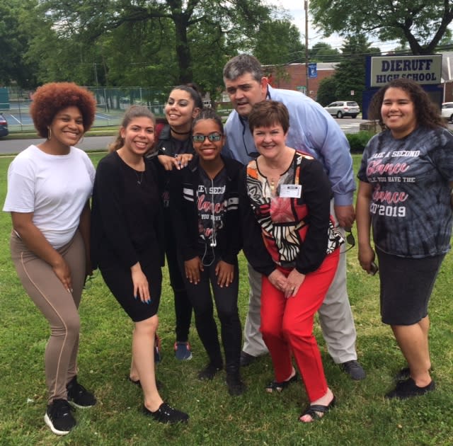 Recent high school graduate Gigi Valoy poses with her professor, Sandy Kiles, and some classmates after trying on color blind corrective glasses for the first time. (Credit: Sandy Kiles)