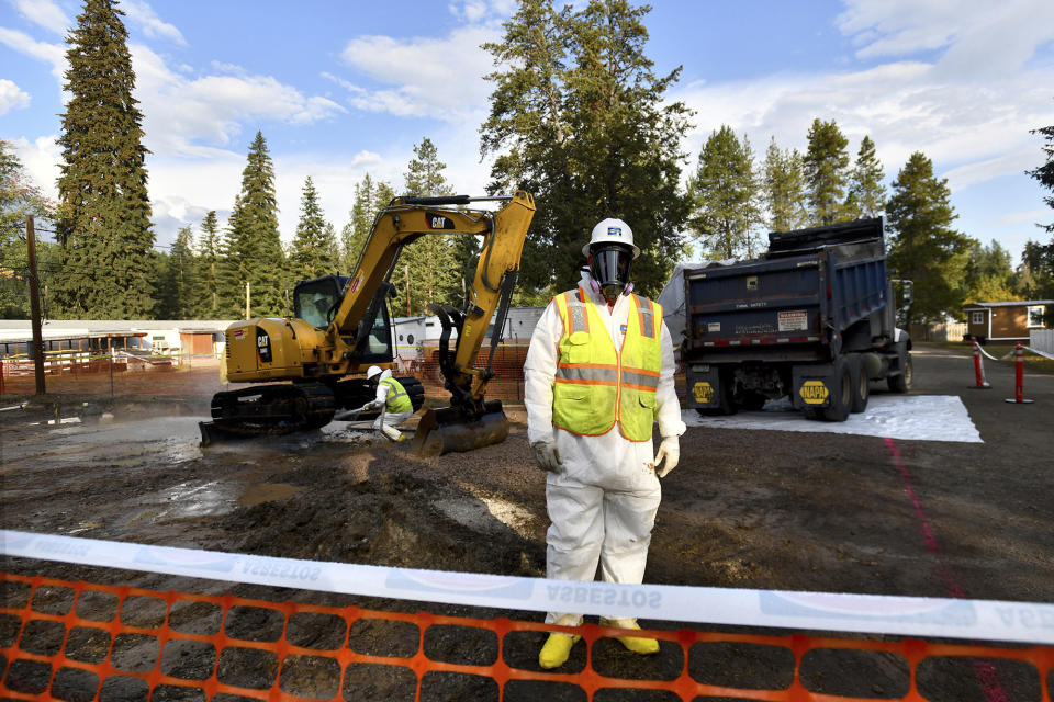 FILE - Environmental cleanup specialists work at an asbestos cleanup site in Libby, Montana, on Sept. 13, 2018. A lawsuit being tried in federal court alleges BNSF Railway knew the vermiculite it was hauling through Libby from a nearby mine was tainted with asbestos. The railroad denies the allegations. (Kurt Wilson/The Missoulian via AP, File)