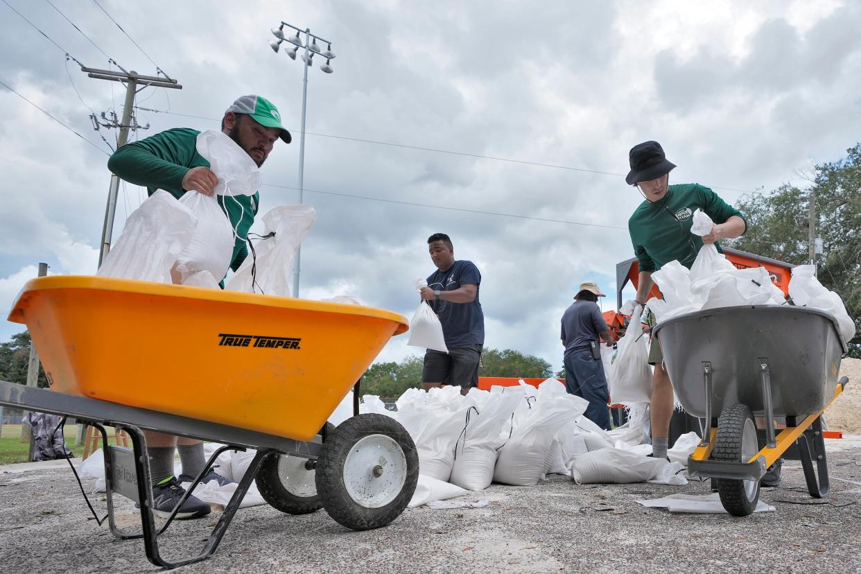 Members of the Tampa, Florida Parks and Recreation Department help residents with sandbags (AP)