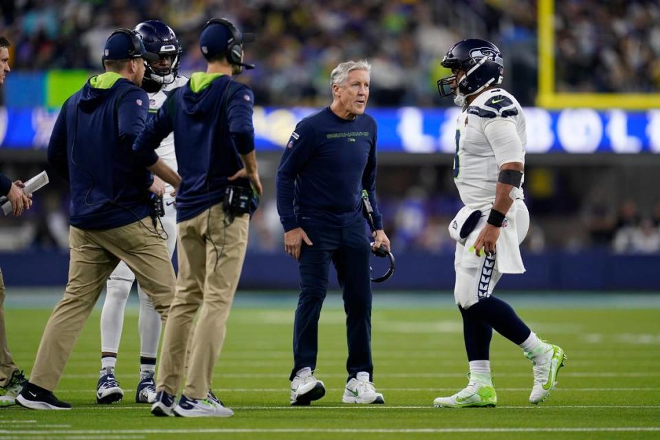 Seattle Seahawks quarterback Russell Wilson, right, walks back to the sideline past head coach Pete Carroll during the first half of an NFL football game against the Los Angeles Rams Tuesday, Dec. 21, 2021, in Inglewood, Calif. (AP Photo/Ashley Landis)