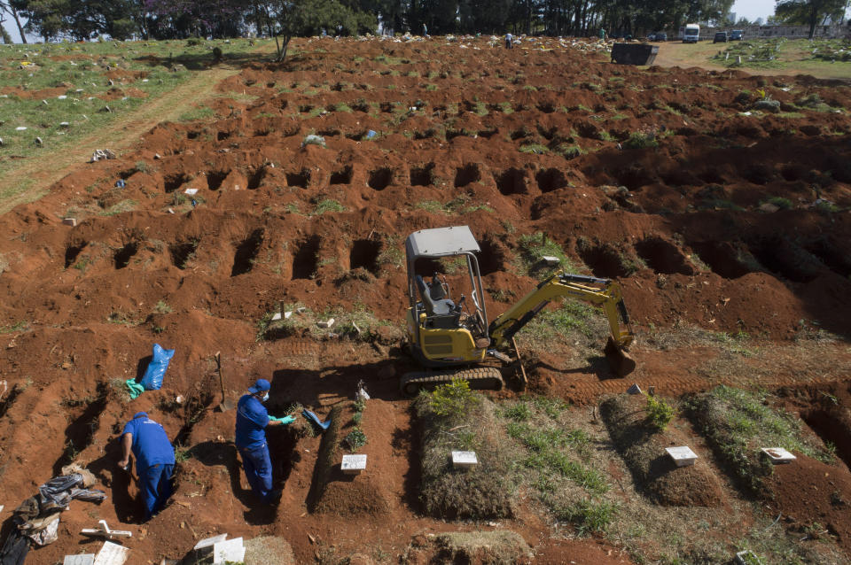 Trabajadores exhuman cadáveres sepultados hace tres años en el cementerio de Vila Formosa, que no cobra a las familias por las tumbas, en Sao Paulo, Brasil, el 12 de junio de 2020. Los cuerpos sepultados hace al menos tres años, se exhuman y almacenan en bolsas de plástico para dejar sitio a más féretros, una necesidad más acuciante en la pandemia del coronavirus. (AP Foto/Andre Penner)