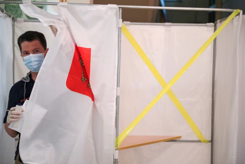 A man walks out of a booth during a nationwide vote on constitutional reforms in Moscow