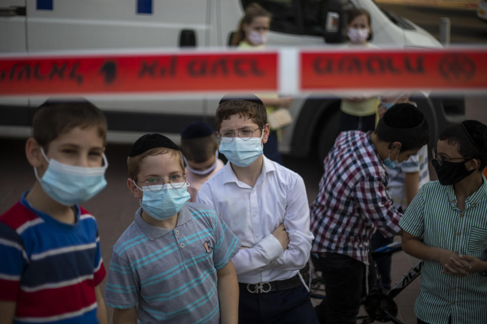 Ultra-Orthodox Jewish children wear face masks amid the coronavirus pandemic as they gather in Bnei Brak, Israel Sunday, Sept. 6, 2020. The death toll from the coronavirus in Israel has surpassed 1,000, as the government on Sunday mulled steps for imposing new restrictions to quell a resurgence in infections. (AP Photo/Ariel Schalit)