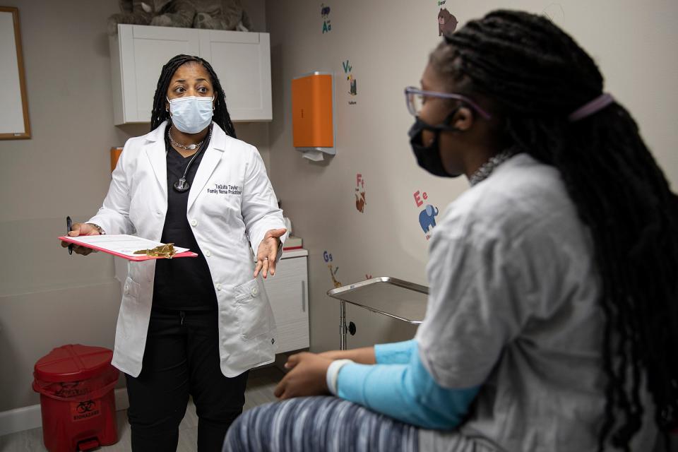 Family nurse practitioner TaQuita Taylor (left) talks to 12-year-old Jamariah Patton, 12, after her sports physical on Wednesday March 23, 2022, at Children Express Care Clinic in Indianapolis. 