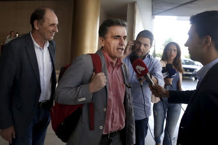 Greek Finance Minister Euclid Tsakalotos (C) speaks to the media while Economy Minister George Stathakis (L) looks on as they leave a hotel following an overnight meeting with representatives of the International Monetary Fund, the European Commission, the European Central Bank and the eurozone's rescue fund, the European Stability Mechanism in Athens, August 11, 2015. REUTERS/Alkis Konstantinidis