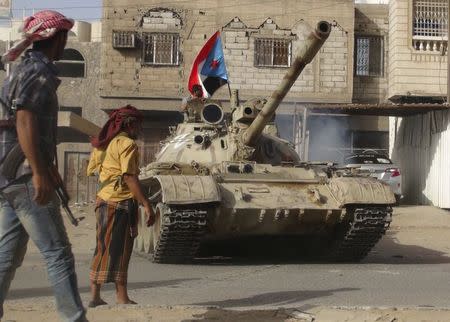 Militants loyal to Yemen's President Abd-Rabbu Mansour Hadi stand by a tank they used in fighting against Houthi fighters in the southern port city of Aden April 11, 2015. REUTERS/Stringer