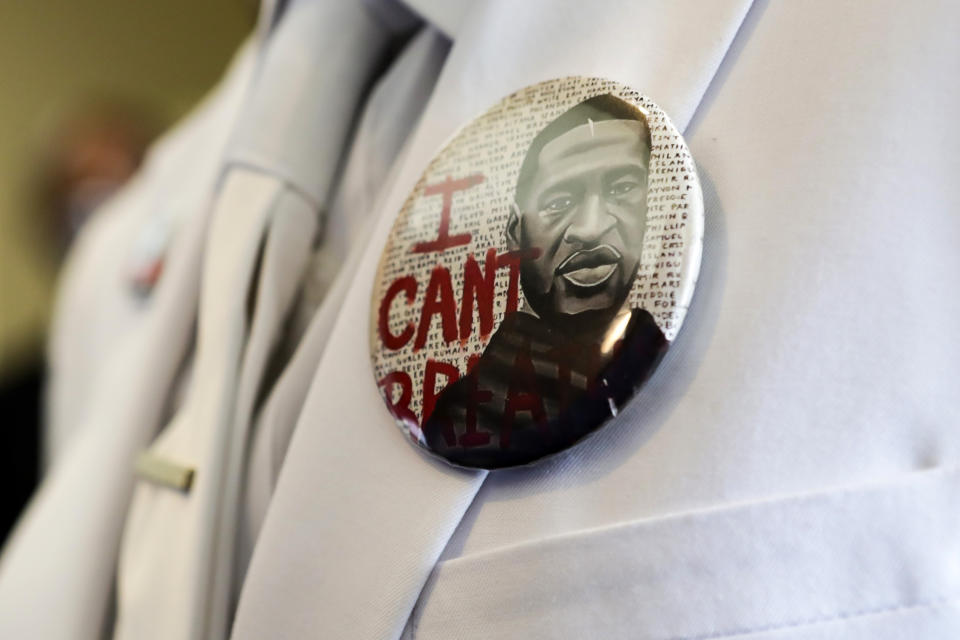 FILE- A button that reads "I can't breathe," adorns the jacket of a mourner before the funeral for George Floyd on Tuesday, June 9, 2020, in Houston. Political observers are watching whether Texas' governor will posthumously pardon Floyd for a 2004 arrest before the end of the year. (Godofredo A. Vásquez/Houston Chronicle via AP, Pool, File)