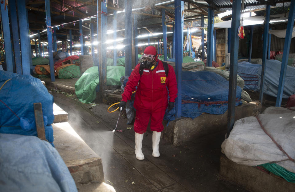 Un trabajador de la ciudad fumiga para ayudar a contener la propagación del nuevo coronavirus en un mercado normalmente abarrotado en La Paz, Bolivia, el lunes 30 de marzo de 2020. (AP Foto / Juan Karita)