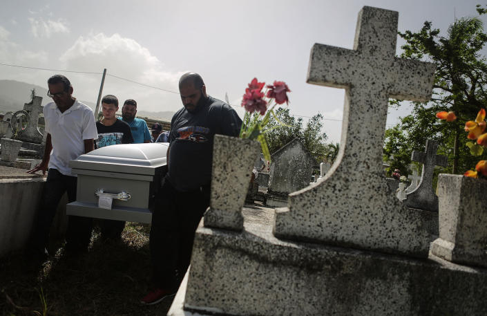 <p>Mourners carry the casket of Wilfredo Torres Rivera, 58, who died Oct. 13 after jumping off a bridge into a lake, three weeks after Hurricane Maria, on Oct. 19, 2017 in Utuado, Puerto Rico. Utuado was one of the hardest hit areas on the island and remains largely without grid electricity or running water. Wilfredo’s family said he suffered from depression and schizophrenia and was caring for his 92-year-old mother in a home without electricity or water in the aftermath of Maria. They believe he did not have the mental tools to manage the challenges of the storm’s aftermath. The family was concerned and brought Wilfredo to a doctor shortly before his death but they say he was not provided with adequate care or counseling. While the government has ruled his death a suicide, the family believes his death should be classified as a death caused by Hurricane Maria. (Photo: Mario Tama/Getty Images) </p>