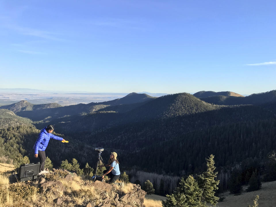 In Oct. 23, 2017 photo provided by "Ways of Knowing," filmmakers, Carmile Garcia, right, and Kayla Briet use a 360 VR video rig cameras in Mount Taylor, regarded by the Navajo as one of four sacred mountains in N.M. Activists are using virtual reality technology to focus on areas of the Navajo Nation affected by uranium contamination. (Adriel Luis/Ways of Knowing via AP)