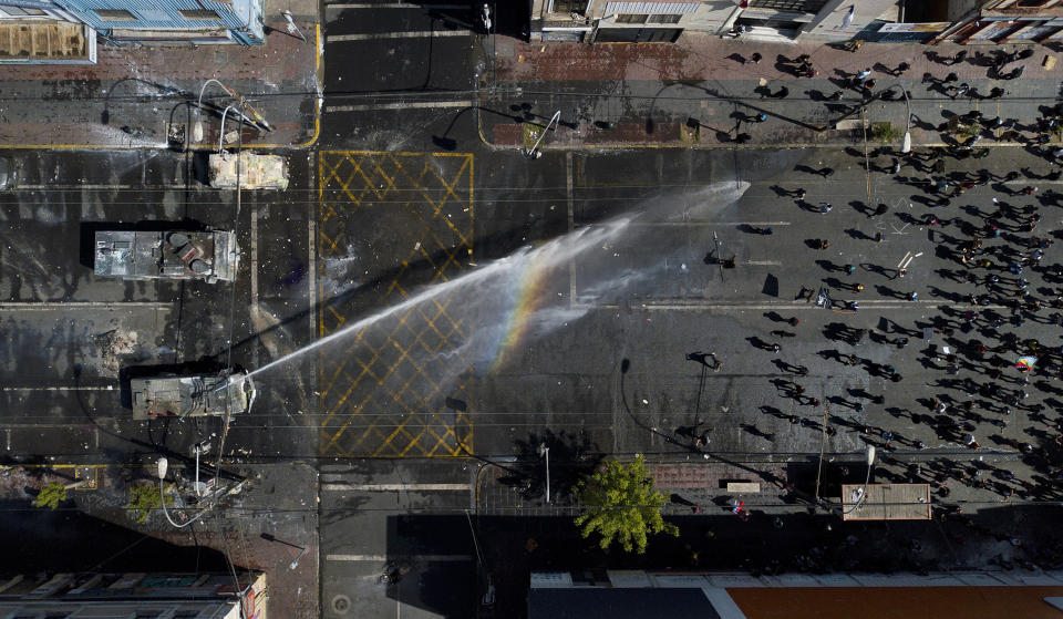 A police water cannon sprays anti-government demonstrators in Valparaiso, Chile, on Oct. 26, 2019. (AP Photo/Matias Delacroix)