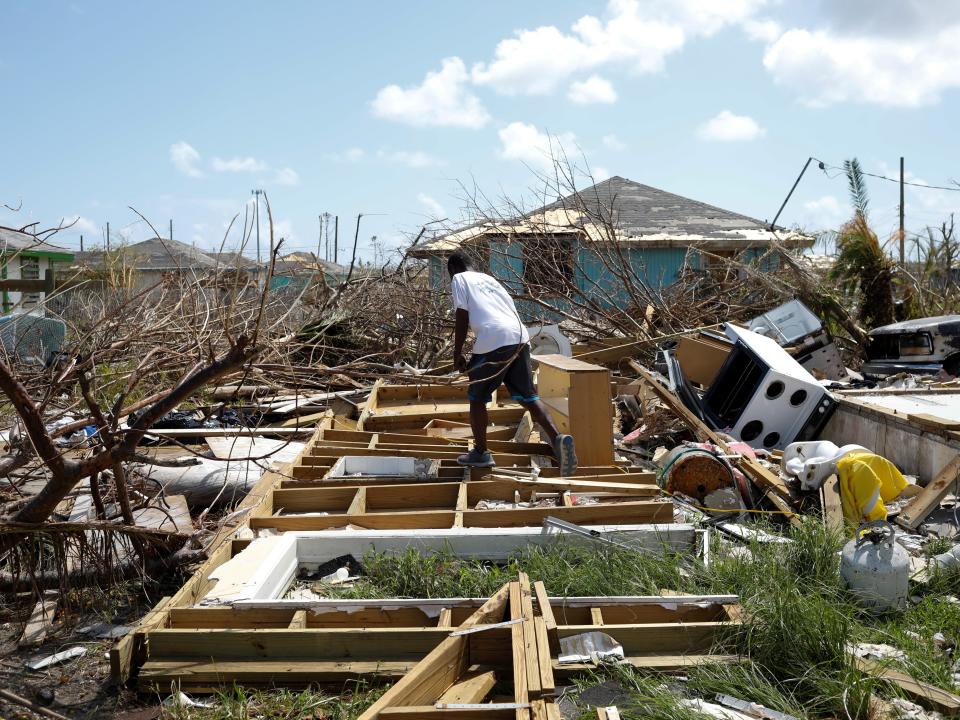 FILE PHOTO: A man walks among the debris of his house after Hurricane Dorian hit the Abaco Islands in Spring City, Bahamas, September 11, 2019. REUTERS/Marco Bello - RC1D219815D0/File Photo