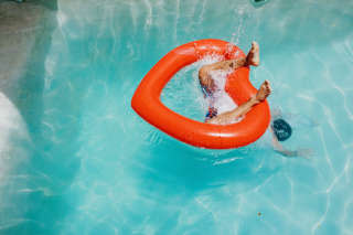 Man's feet protruding as he dives through heart-shaped inflatable