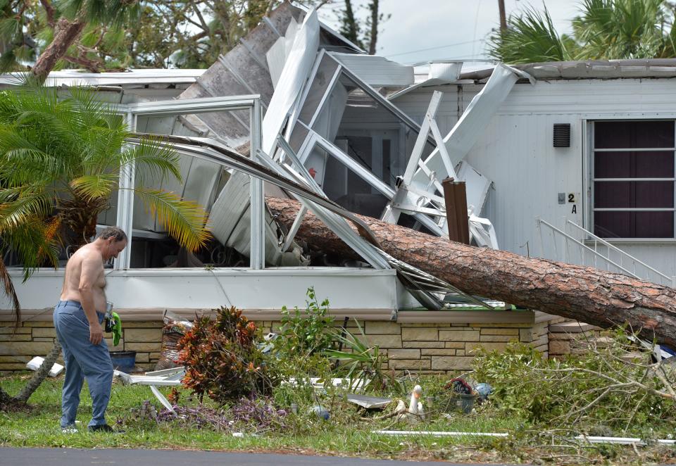 Don Mendenall picks up debris in his yard at Oak Grove mobile home park in Englewood on Thursday, Sept. 29, 2022, after a pine tree fell on his trailer during Hurricane Ian. Mendenall was not home during the storm.