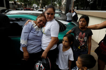 Cyntia (L) mother of Saylin, 14, who, according to the police, was killed by Barrio-18 gang members, waits for Saylin's body outside a morgue in Tegucigalpa, Honduras, July 18, 2018. According to police authorities, Saylin was kidnapped and tortured by her killers. REUTERS/Edgard Garrido