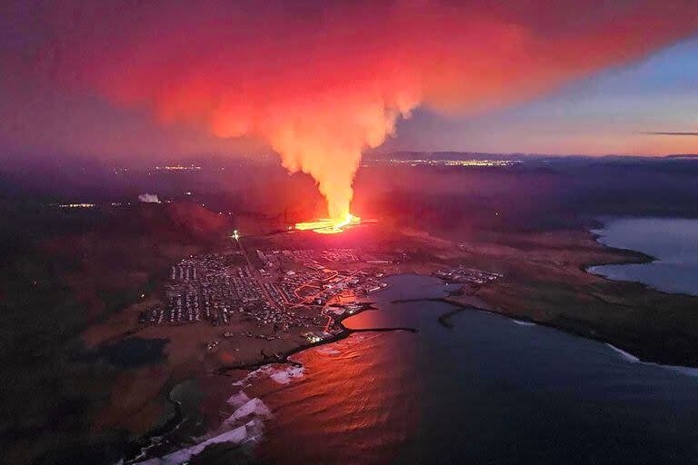 En esta imagen proporcionada por el Departamento de Protección Civil y Gestión de Emergencias de Islandia el 14 de enero de 2024, se observa humo que se eleva y lava fluyendo durante una erupción volcánica en las afueras de la evacuada ciudad de Grindavik, en el oeste de Islandia.