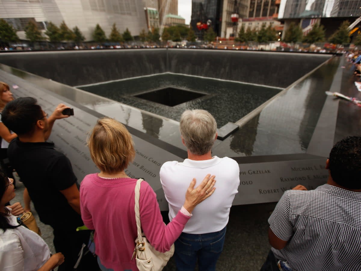 Family members of 9/11 victims stand at the edge of one of the memorial pools in New York City on the attack’s 10th anniversary in 2011 (Chip Somodevilla/Getty Images)