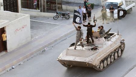 Militant Islamist fighters take part in a military parade along the streets of northern Raqqa province June 30, 2014. REUTERS/Stringer