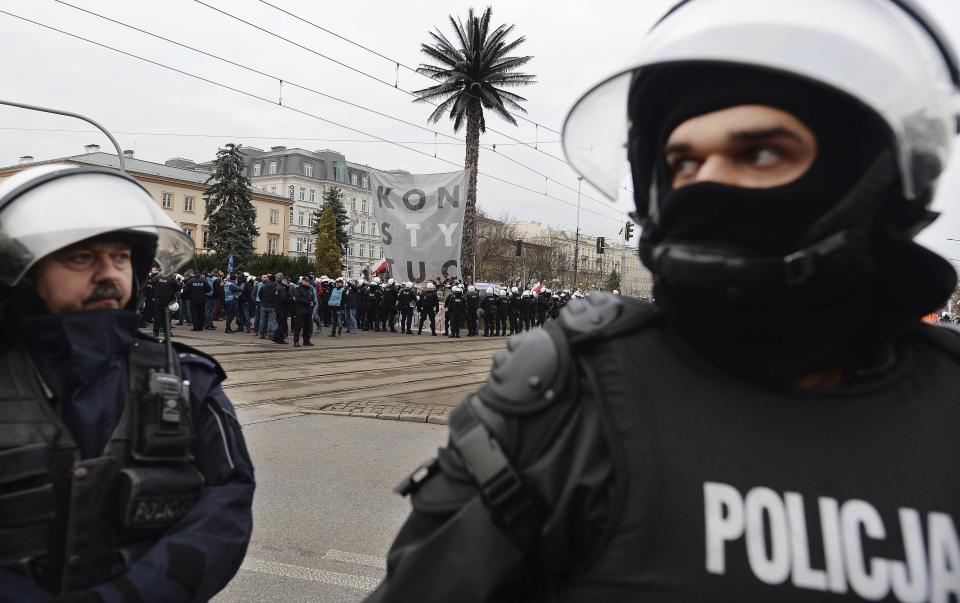 Police stand guard as counter-protesters stand along the path of people taking part in the March of Independence organized by far right activists to celebrate 101 years of Poland's independence, in Warsaw, Poland, Monday, Nov. 11, 2019. Officers later removed the counter protesters. (AP Photo/Czarek Sokolowski)