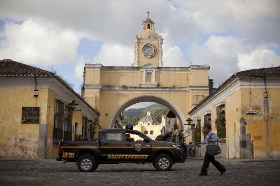 In this Nov. 14, 2013 photo, police patrol along a main street close to the Santa Catalina convent in Antigua, Guatemala. Vehicle and home burglaries are up, and once-reliable public services such as water and trash collection have been left unattended across whole blocks. (AP Photo/Luis Soto)