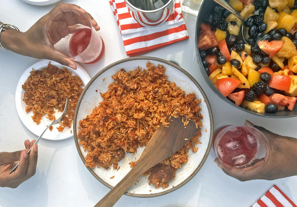 A traditional serving of jollof rice, ready to be enjoyed, with a side of refreshing mixed fruit salad, exemplifying the balance of spice and sweetness in West African meals. (Courtesy Nana Araba Wilmot)